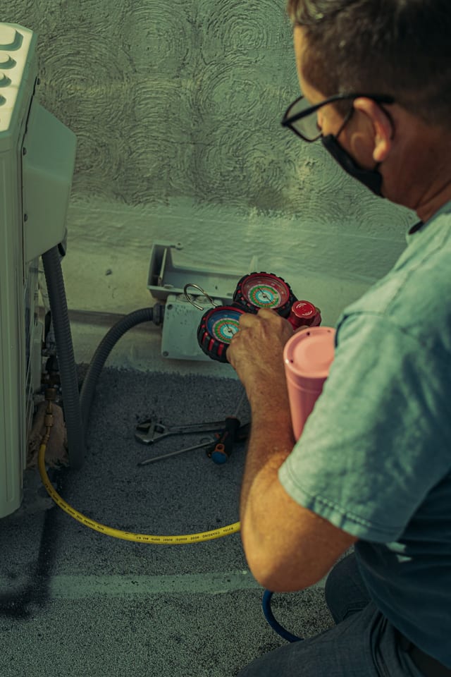 HVAC technician carefully servicing equipment